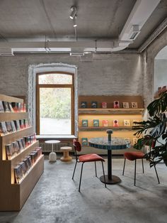 the interior of a book store with several books on shelves and chairs around a table