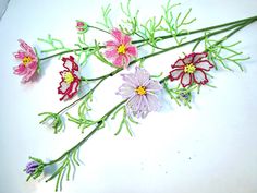 some flowers that are sitting on a white table together and one is pink, yellow and purple