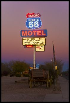 a motel sign with a wagon underneath it