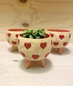 three planters with hearts painted on them