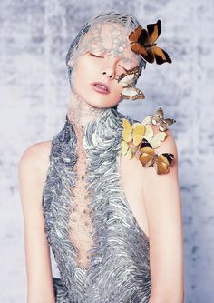 a woman in a silver dress with butterflies on her shoulder