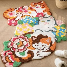 three rugs with cats and flowers on them are sitting on the floor next to shoes