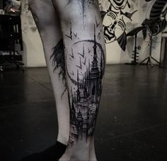 a black and white photo of a person's leg with a castle tattoo on it