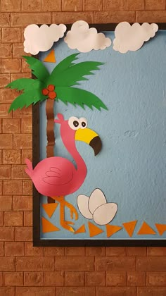 a paper flamingo with a palm tree and clouds in the background on a brick wall