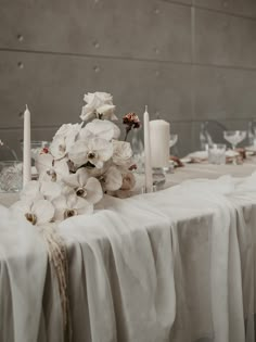 the table is set with white flowers and candles