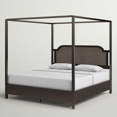 a bed that is made up and has white sheets on it, with a black headboard