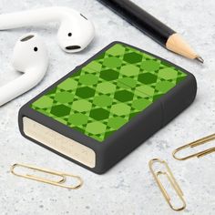 a book with green squares on it next to earphones and other items that include paper clips