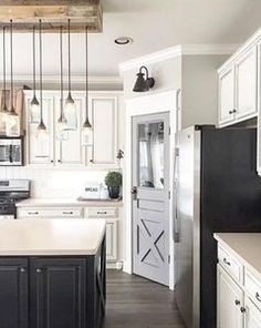 a kitchen with white cabinets, black appliances and an island in front of the refrigerator