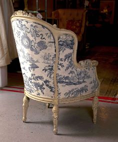 an old chair with blue and white designs on it