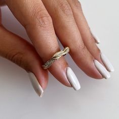 a woman's hand with white manies and a gold ring on her finger