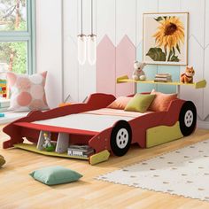 a child's bedroom with a car bed and toy cars on the floor in front of it