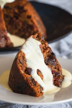 a piece of carrot cake on a plate with icing and white frosting next to it