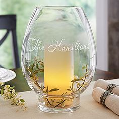 a glass vase with a candle in it sitting on a table