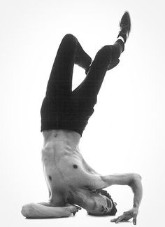 a man is doing a handstand on the floor with his feet in the air