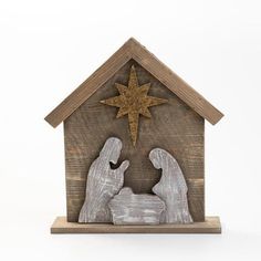 the nativity scene is made out of wood and has a star on top of it