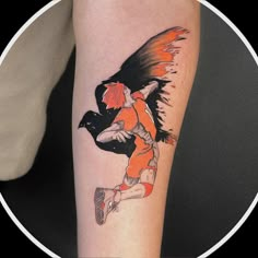 a woman's arm with an orange and black tattoo design on the left side of her leg