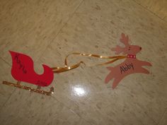 a christmas ornament on the floor with a name tag attached to it