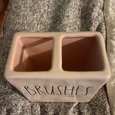 a couple of bowls sitting on top of a bed next to each other with the words brushes written on them