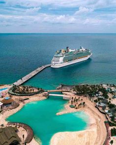 a cruise ship docked in the ocean next to a beach and pier with blue water