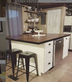 a kitchen island with stools in front of it