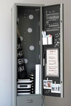 an open locker with pictures and writing on the wall next to a notepad holder