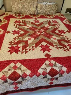 a bed with a red and white quilt on it