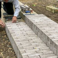 a man laying bricks on the ground