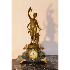 a clock with a statue on top of it