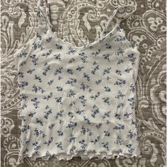 Never Worn Hollister Tank Top Blue And White Floral Design Lettuce Cut On The But Of Tank Top White Printed Cami Tops, Blue Printed Cami Top, Casual White Floral Print Tank Top, White Casual Tank Top With Floral Print, Casual White Tank Top With Floral Print, White Floral Print Cami Top, Casual Floral Print Crop Top Tank, Blue Floral Print Casual Tank Top, Blue Floral Print Cami Top