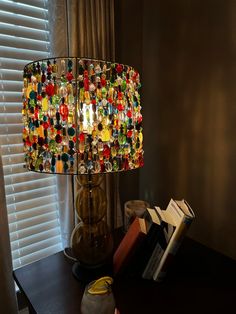 a lamp that is sitting on top of a table next to a book and some books