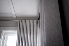 the corner of a room with a radiator in it and a window above