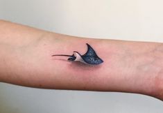 a small bird tattoo on the left arm