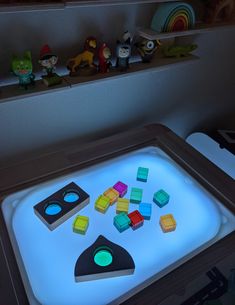 a lit up table with toys on it in the shape of an electronic device and other items