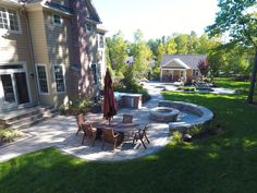 an outdoor patio with table and chairs next to a large house in the back yard