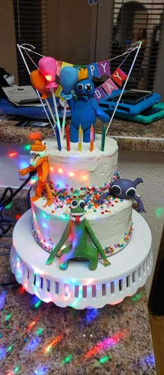 a birthday cake decorated with balloons and decorations