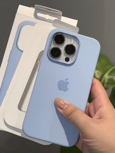 a person holding up an iphone case in front of two boxes with the cover open