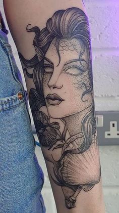 a woman's arm with a tattoo on it, and flowers in her hair