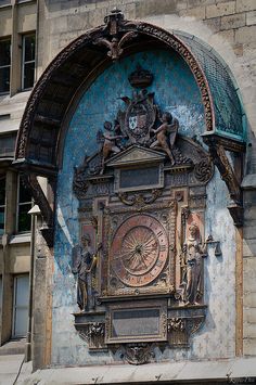 an ornate clock mounted to the side of a building