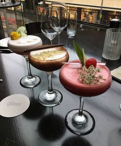 three different types of drinks sitting on top of a black table next to each other