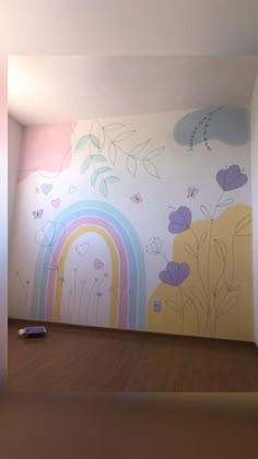 an empty room with a rainbow painted on the wall