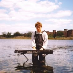 a man standing in the water with a keyboard