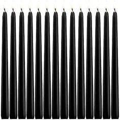 twelve black candles are lined up in a row on a white background, with one lit candle