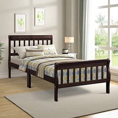 a bed room with a neatly made bed next to a large window and a potted plant