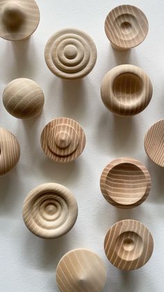 several wooden bowls are arranged on a white surface, each with different shapes and sizes