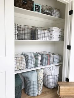 the closet is organized with baskets and towels