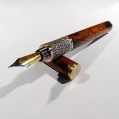 a fountain pen sitting on top of a white table