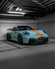 a blue and orange sports car parked in a garage