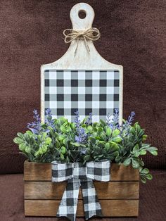 a wooden box with plants in it and a sign hanging on the wall behind it