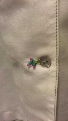 a white shirt with flowers on it and a button