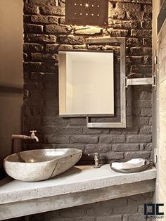 a bathroom with two sinks and a mirror on the wall next to a brick wall